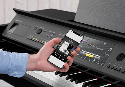 Ruka se smartphonem předvádí aplikaci Smart Pianist u digitálního piana Yamaha CVP-809.